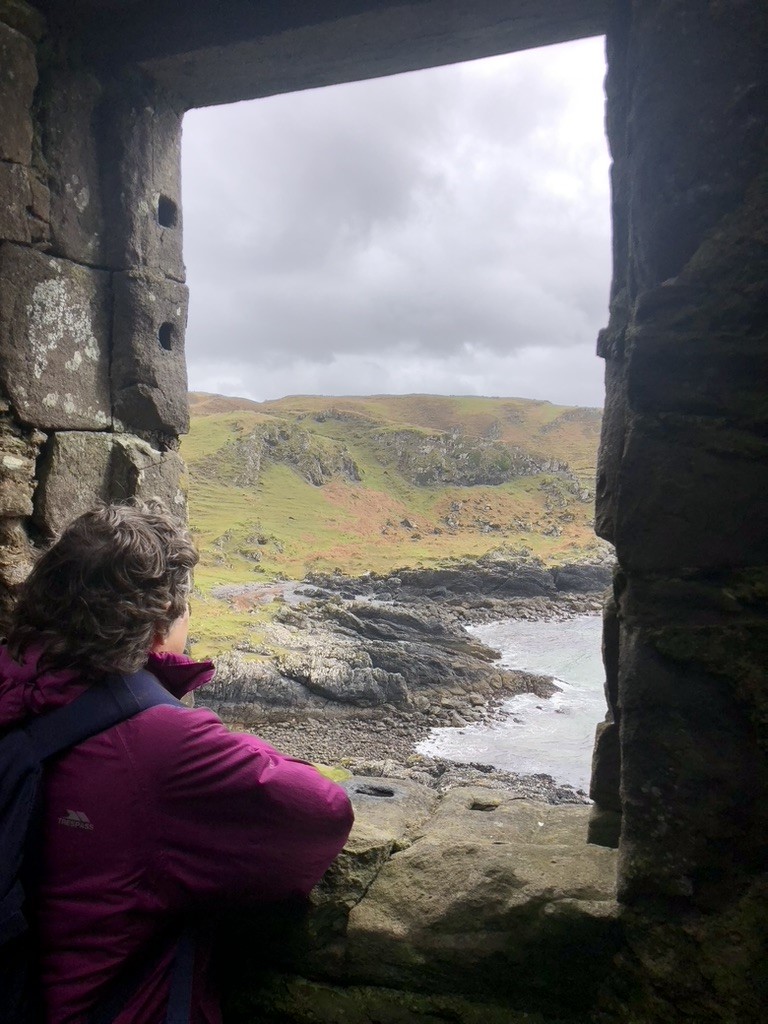 A view of a bay through a rectangular stone window.